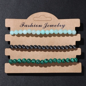 Detailed macro view of a 3-piece set featuring colorful natural stone bead bracelets on kraft card