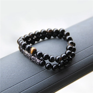 Detail of double-layer beaded bracelet with tiger eye stone and silver hollow metal tube