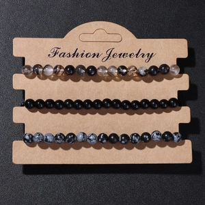 Detailed macro view of three 8mm natural stone elastic bracelets on a jewelry card