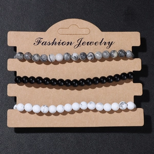 Detailed view of 3-piece natural stone bead bracelets on a fashion jewelry display card