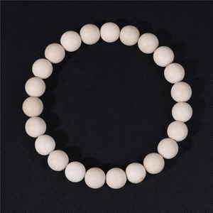 Detailed macro view of 8mm matte white natural stone beads on a flexible elastic bracelet