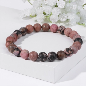 Detailed view of 8mm natural stone beaded bracelet with pink and black rhodonite textures