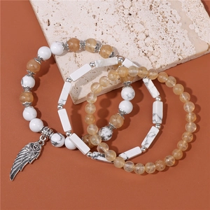 Dettaglio di set di bracciali bohémien con turchese bianco e ciondolo ad ala