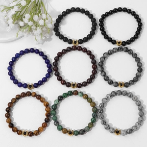 Dettaglio di otto bracciali in pietre naturali con ciondoli a ferro di cavallo dorati