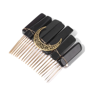Detail of vintage gothic hair comb with gold crescent moon and black resin base