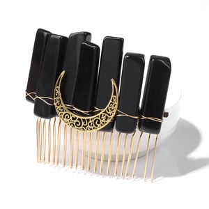 Detail view of bohemian hair comb with black stones and golden moon crescent accessory