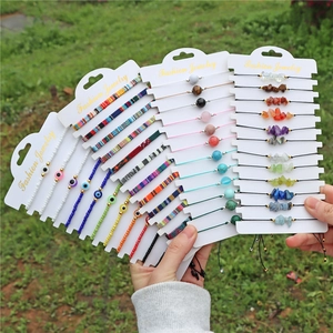 Close-up of bohemian gemstone beaded bracelets with evil eye charms on white display cards