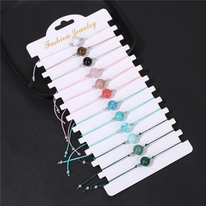 Detail view of 12pcs adjustable braided stone bead bracelets on a jewelry card