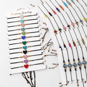 Detail of colorful glitter heart charms and evil eye beads on braided rope bracelets