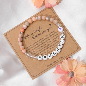 Close-up of natural stone bead bracelet with DAUGHTER letter beads on a kraft gift card