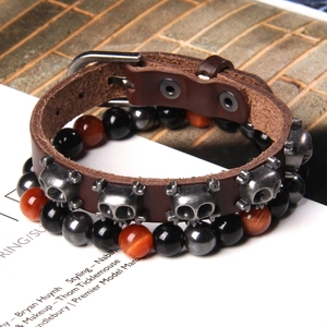 Detail of leather punk bracelet with skull studs and natural tiger eye stone beads