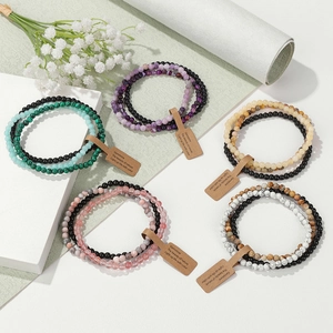 Close-up of triple-layered 4mm natural amethyst and stone bead bracelets with tags