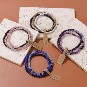 Detail of four layered natural stone bead bracelet sets with vintage paper labels