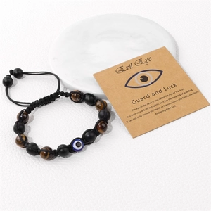 Detail eines verstellbaren Tigerauge-Armbands mit Evil Eye auf einer Infokarte