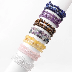 Detail view of seven layered natural chip stone bracelets on a white display cylinder