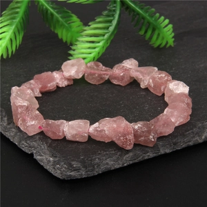 Natural pink raw crystal chip bracelet on black rock with green plant accent for men and women