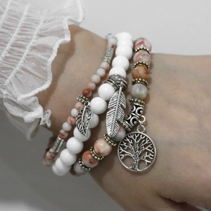 Detail of bohemian layered stone bead bracelet with tree of life and leaf charms