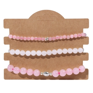 Gros plan du lot de bracelets en perles roses et blanches avec breloque argentée sur carte