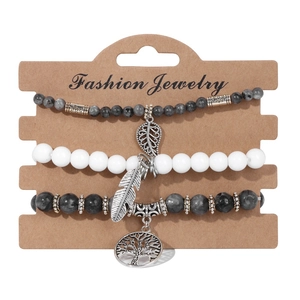 Detail of tree of life and feather charms on bohemian marble bead bracelet set