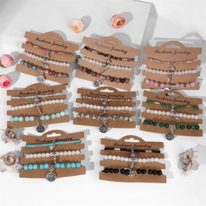 Gros plan de bracelets bohèmes en perles avec breloques lotus et feuilles sur cartes