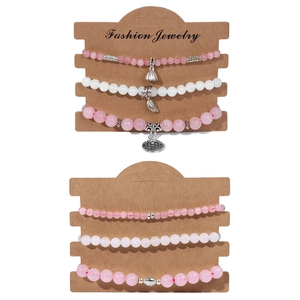 Détail de parures de bracelets en perles de pierre naturelle rose et blanc avec breloques