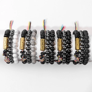 Détail de cinq bracelets ethniques en perles avec pierres de lave et cordon tissé coloré