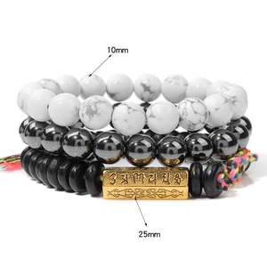 Gros plan détaillé des perles en oeil de tigre et du pendentif mantra doré, lot de 3 bracelets