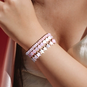 Driedelige roze schelpkraalarmband set met hart en ster bedels op roze zijde