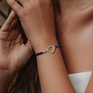 Bracelet en perles de pierre violettes facettées avec fermoir à bascule doré martelé