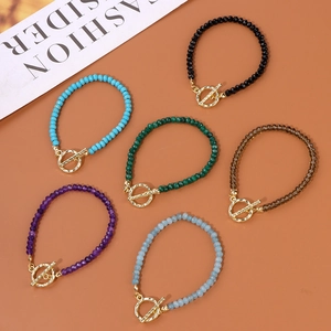Vue à plat de bracelets en pierres facettées multicolores avec fermoirs à bascule dorés