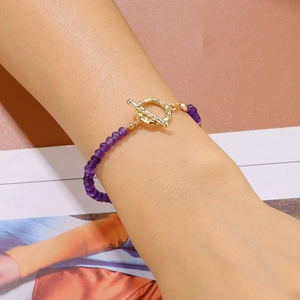 Détail d'un bracelet en pierres violettes facettées avec fermoir à bascule doré