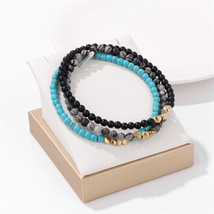 Detailed close-up of a three-piece 4mm natural stone bead bracelet set with gold spacers