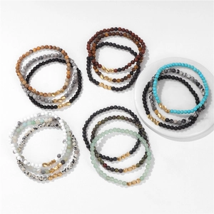 Detailed view of natural stone beads with irregular gold metal spacers on white surface