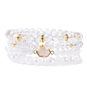 Détail d'un lot de quatre bracelets en perles de cristal avec breloque hexagonale dorée