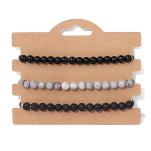 Dettaglio del set di 3 braccialetti con perline di lava nera e marmo presentati su scheda