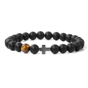 Nahaufnahme von matten schwarzen Perlen, Tigerauge und grauem Kreuzanhänger am Perlenarmband