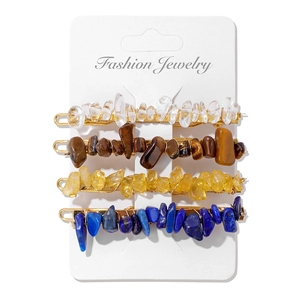 Detailed close-up of four gold metal hairpins set with assorted natural irregular stones