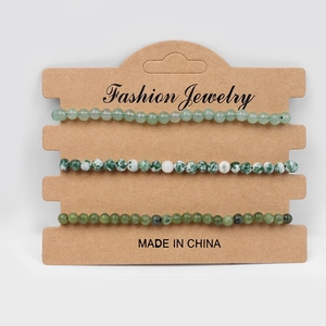 Three-piece set of natural green stone beaded bracelets on brown card packaging