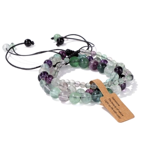Close-up of three layered fluorite beaded bracelets with natural purple and green stones