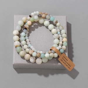 Vista macro de pulseras de cuentas de piedra natural en varios tamaños con etiqueta kraft