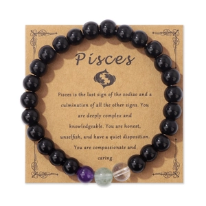 Dettaglio del bracciale con perline Pesci su carta kraft con pietre nere e cristalli naturali