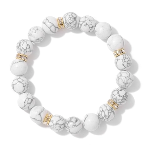 Détail de perles de pierre blanche de 10mm avec des entretoises dorées en strass