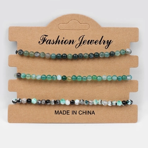 Three-piece natural stone bead bracelet set in green and black on display card