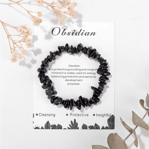Vue détaillée du bracelet en obsidienne noire sur carte avec décor de feuilles naturelles