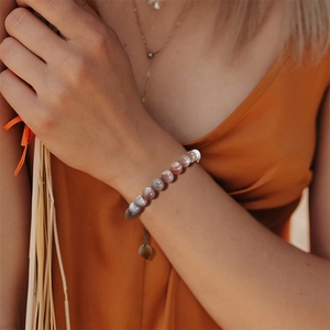 Detail van verstelbare natuurstenen kralenarmband gedragen met warme bohemien kleding