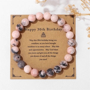 Detalle de pulsera de cuentas de piedra natural rosa con tarjeta de cartón kraft