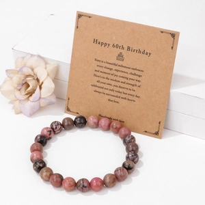 Detalle de pulsera de cuentas de piedra natural para el 60 cumpleaños con tarjeta kraft