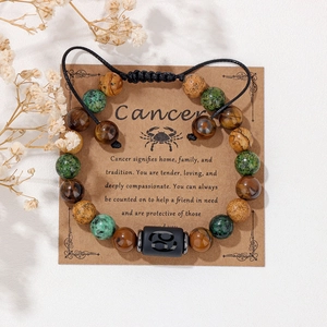 Dettaglio macro del bracciale zodiaco Cancro con pietre naturali su cartoncino