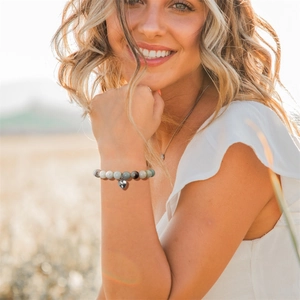 Bracelet en perles de pierre naturelle avec breloque cœur porté par un mannequin