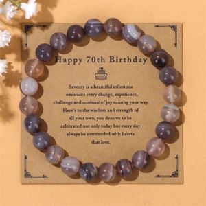 Detalle de pulsera de cuentas de ágata a rayas con tarjeta de regalo de 70 cumpleaños